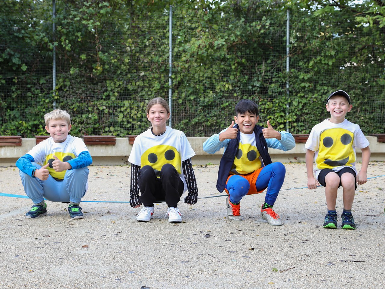Vier Kinder mit Smiley-T-Shirt im Kinderheim Brugg
